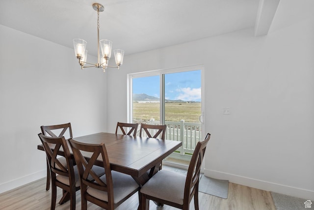 6636 W Ipswitch Way S, Herriman, UT 84096 - dining room with baseboards, light wood-style floors, a chandelier, and a mountain view