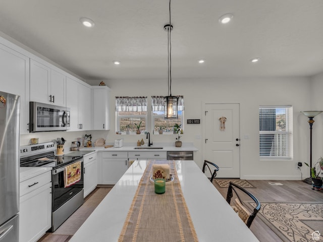 4423 E Longleaf Ln, Eagle Mountain, UT 84005 - kitchen featuring stainless steel appliances, a sink, hanging light fixtures, recessed lighting, and white cabinetry