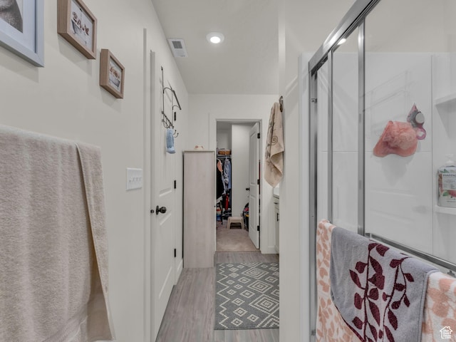 4423 E Longleaf Ln, Eagle Mountain, UT 84005 - bathroom featuring wood finished floors, a shower stall, a spacious closet, and recessed lighting