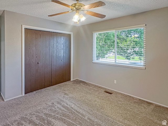 485 W Cottonwood Ln, Ferron, UT 84523 - unfurnished bedroom featuring carpet flooring, a closet, a textured ceiling, a ceiling fan, and baseboards