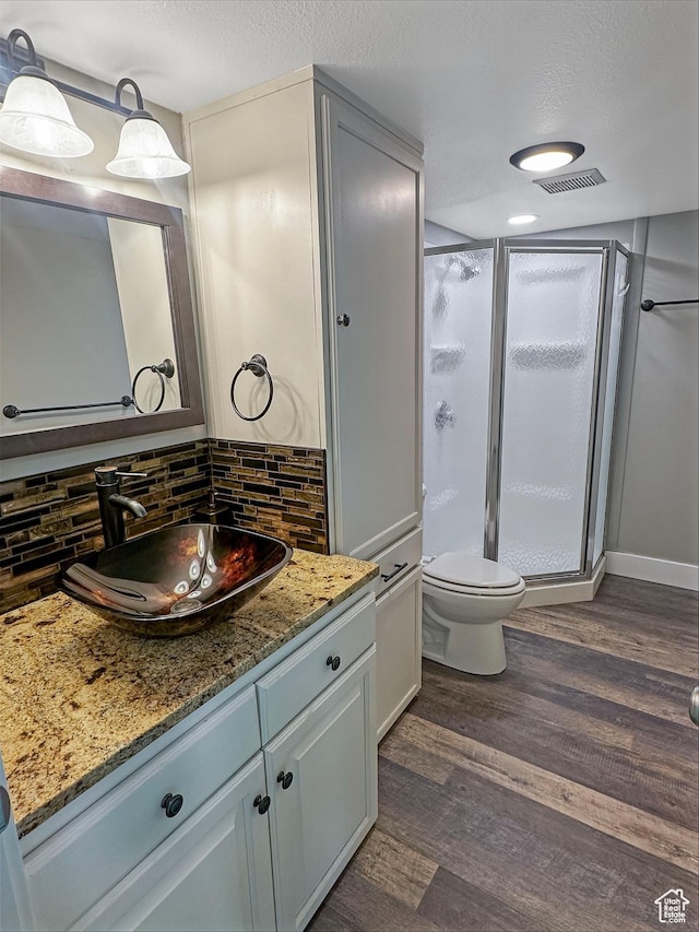 485 W Cottonwood Ln, Ferron, UT 84523 - full bath featuring wood finished floors, a stall shower, decorative backsplash, vanity, and toilet