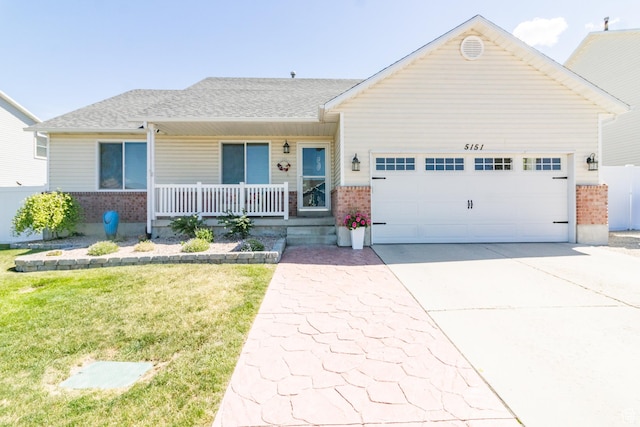 5151 Case Mountain Rd, West Jordan, UT 84081 - view of front facade with brick siding, a porch, a garage, driveway, and a front yard