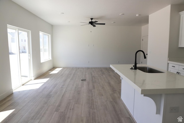 3725 N Janie St Unit 1013, Eagle Mountain, UT 84005 - unfurnished living room featuring a sink, light wood finished floors, a ceiling fan, and baseboards