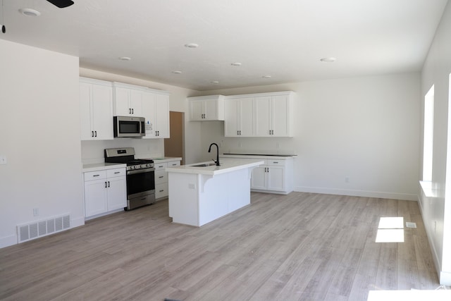 3725 N Janie St Unit 1013, Eagle Mountain, UT 84005 - kitchen with stainless steel appliances, a sink, light wood-type flooring, and white cabinets