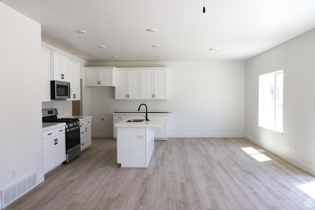 3725 N Janie St Unit 1013, Eagle Mountain, UT 84005 - kitchen with appliances with stainless steel finishes, a sink, a center island with sink, light wood finished floors, and recessed lighting