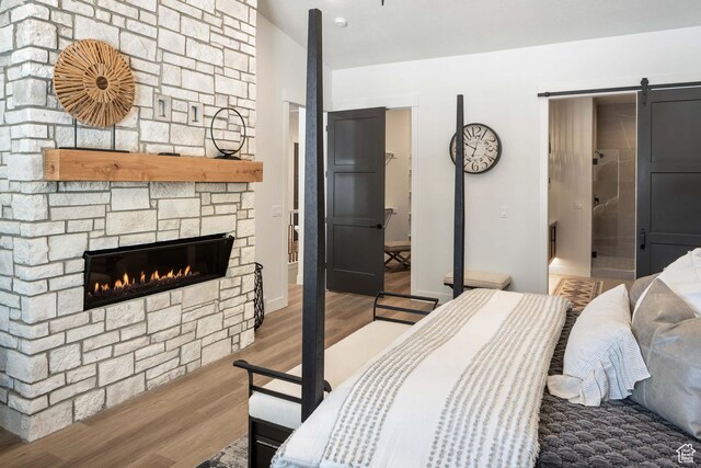 1252 W 770 S Unit 104, Heber City, UT 84032 - bedroom with wood finished floors, a barn door, and a fireplace