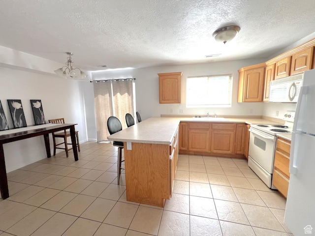 1167 E 400 S Unit 22, St George, UT 84790 - kitchen with white appliances, a sink, a kitchen breakfast bar, a peninsula, and light countertops