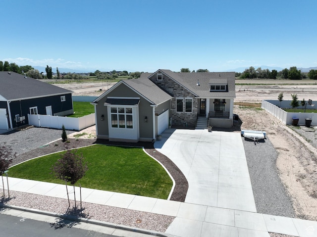 4817 W 50 S, West Point, UT 84015 - view of front of home featuring an attached garage, concrete driveway, stone siding, and covered porch