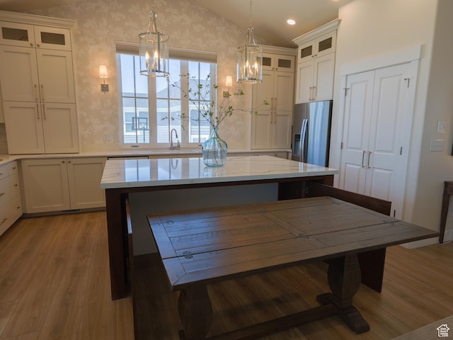 4817 W 50 S, West Point, UT 84015 - kitchen featuring stainless steel fridge with ice dispenser, a chandelier, vaulted ceiling, wood finished floors, and a center island