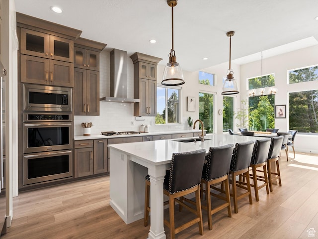 2393 N 300 E Unit 108, Lehi, UT 84043 - kitchen with a sink, wall chimney exhaust hood, appliances with stainless steel finishes, light countertops, and light wood-style floors