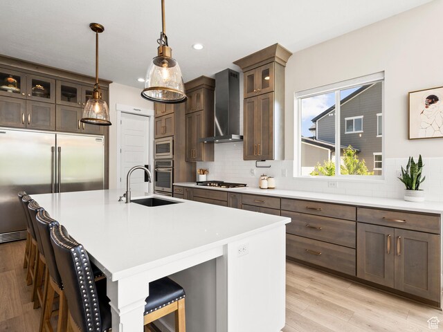 2393 N 300 E Unit 108, Lehi, UT 84043 - kitchen with a sink, built in appliances, wall chimney range hood, a breakfast bar, and decorative backsplash