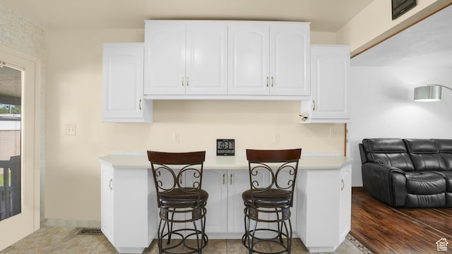 9162 S Pebble Glen Cir, Sandy, UT 84094 - kitchen with white cabinetry, a breakfast bar, light countertops, and open floor plan