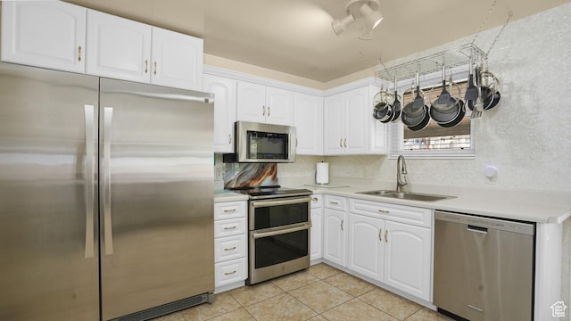 9162 S Pebble Glen Cir, Sandy, UT 84094 - kitchen with stainless steel appliances, a sink, light tile patterned floors, light countertops, and white cabinetry