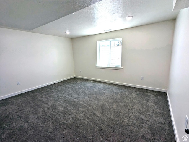 75 N 4th E, Downey, ID 83234 - empty room with dark colored carpet, baseboards, and a textured ceiling