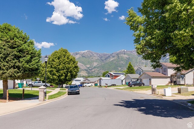 1199 E Pheasant View Dr, Layton, UT 84041 - view of asphalt street with sidewalks, a residential view, curbs, street lights, and a mountain view