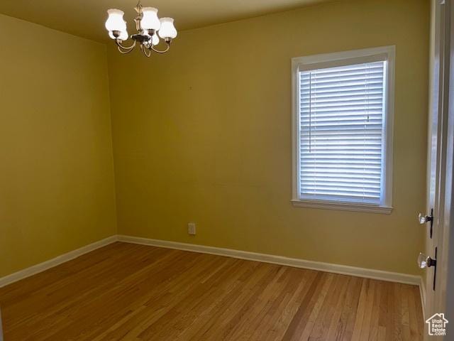2646 S 1700 E, Salt Lake City, UT 84106 - unfurnished room with a chandelier, baseboards, and wood finished floors