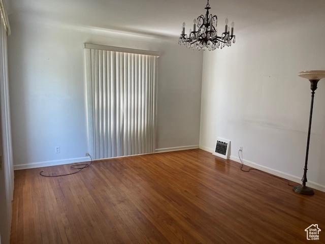 2646 S 1700 E, Salt Lake City, UT 84106 - spare room featuring a chandelier, baseboards, and wood finished floors