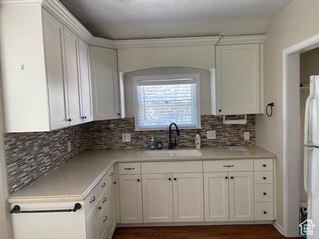 2646 S 1700 E, Salt Lake City, UT 84106 - kitchen with a sink, white cabinetry, freestanding refrigerator, light countertops, and decorative backsplash