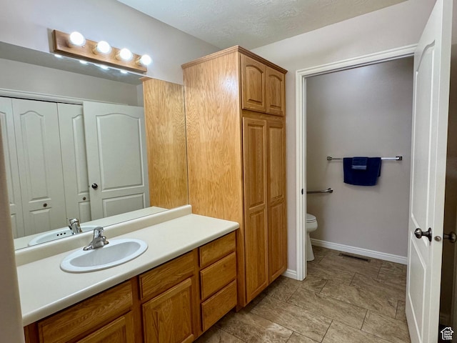445 Topaz Blvd Unit 10, Delta, UT 84624 - bathroom featuring vanity, toilet, a closet, and baseboards