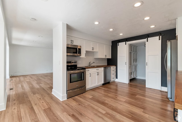 265 N Vine St W Unit 1, Salt Lake City, UT 84103 - kitchen featuring appliances with stainless steel finishes, recessed lighting, a sink, white cabinets, and light wood-style flooring