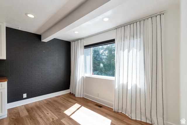 265 N Vine St W Unit 1, Salt Lake City, UT 84103 - empty room with brick wall, baseboards, light wood-style flooring, beam ceiling, and recessed lighting