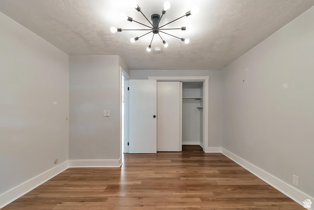 265 N Vine St W Unit 1, Salt Lake City, UT 84103 - unfurnished bedroom featuring a chandelier, a closet, baseboards, and wood finished floors