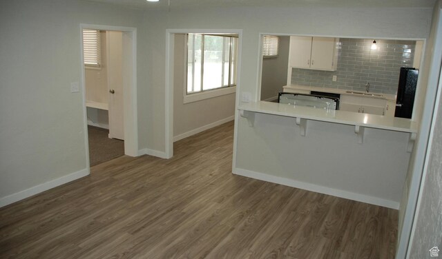 1530 N 2000 W, Farr West, UT 84404 - kitchen featuring a kitchen breakfast bar, a sink, baseboards, and white cabinets
