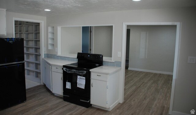 1530 N 2000 W, Farr West, UT 84404 - kitchen featuring black appliances, wood finished floors, light countertops, white cabinetry, and a textured ceiling