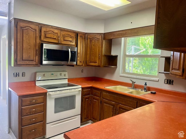 160 E 300 S, Gunnison, UT 84634 - kitchen featuring stainless steel microwave, electric range, open shelves, light countertops, and brown cabinetry