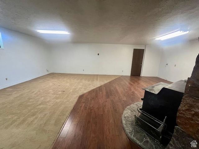 160 E 300 S, Gunnison, UT 84634 - below grade area with a wood stove, wood finished floors, and a textured ceiling