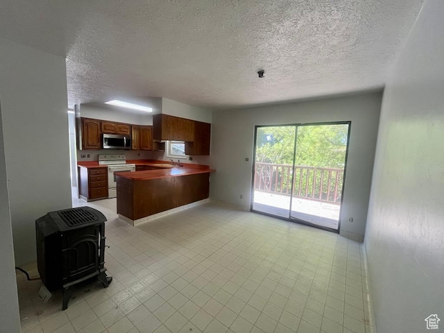 160 E 300 S, Gunnison, UT 84634 - kitchen with stainless steel microwave, white electric stove, a peninsula, a textured ceiling, and open floor plan