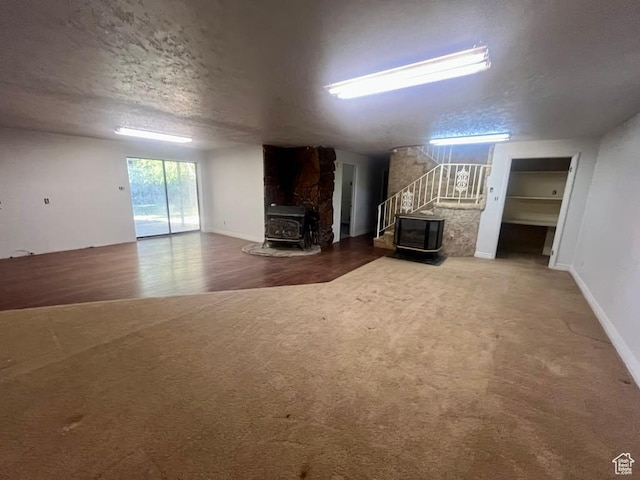 160 E 300 S, Gunnison, UT 84634 - living area featuring a wood stove, stairs, a textured ceiling, and carpet