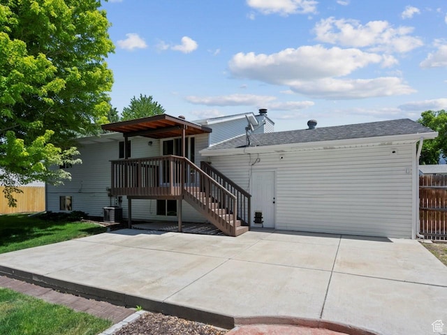 9750 S David St E, Sandy, UT 84070 - back of house with a patio area, concrete driveway, stairway, an attached garage, and a chimney
