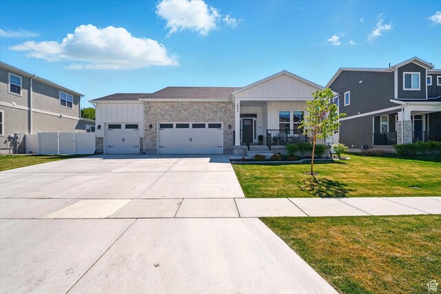 1335 S 1140 E, Heber City, UT 84032 - view of front of home featuring an attached garage, stone siding, driveway, covered porch, and board and batten siding