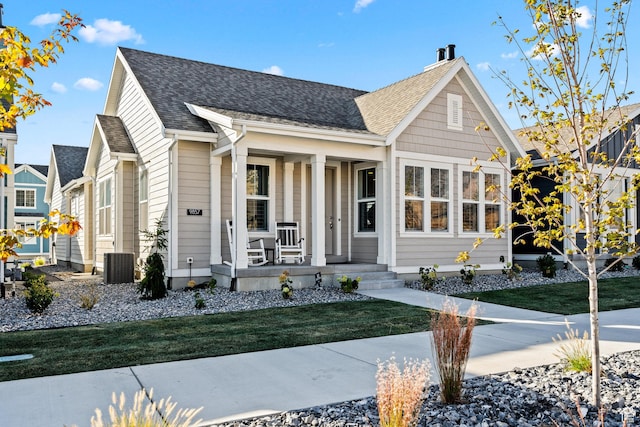 9857 N Featherstone Dr, Highland, UT 84003 - view of front of house with a porch, roof with shingles, a front lawn, and central air condition unit