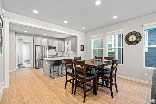 9857 N Featherstone Dr, Highland, UT 84003 - dining space featuring light wood-style floors, baseboards, a textured ceiling, and recessed lighting