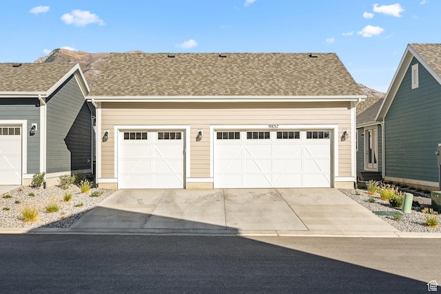 9857 N Featherstone Dr, Highland, UT 84003 - view of front of house with driveway, an attached garage, and roof with shingles