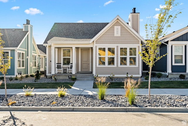 9857 N Featherstone Dr, Highland, UT 84003 - view of front facade with covered porch, a chimney, and a shingled roof