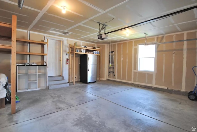 1035 N 130 W Unit 100, Logan, UT 84341 - garage featuring freestanding refrigerator and a garage door opener