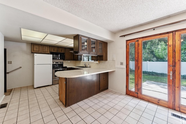 700 E Spruce Glen Rd, Murray, UT 84107 - kitchen with freestanding refrigerator, stainless steel electric stove, black microwave, a peninsula, and light countertops