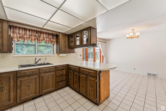 700 E Spruce Glen Rd, Murray, UT 84107 - kitchen with a sink, a peninsula, light countertops, and decorative backsplash