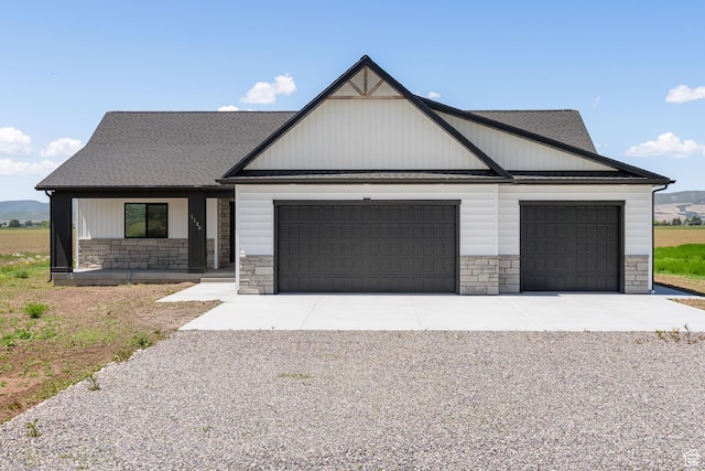 1120 S 800 W, Lewiston, UT 84320 - modern farmhouse style home featuring stone siding, an attached garage, gravel driveway, and a porch