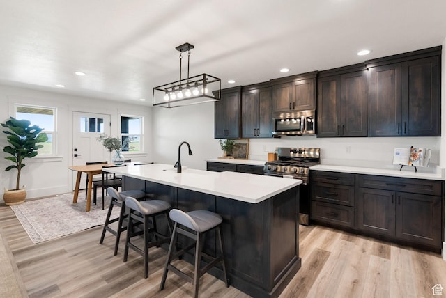 1120 S 800 W, Lewiston, UT 84320 - kitchen featuring stainless steel appliances, light wood-type flooring, a breakfast bar, light countertops, and recessed lighting