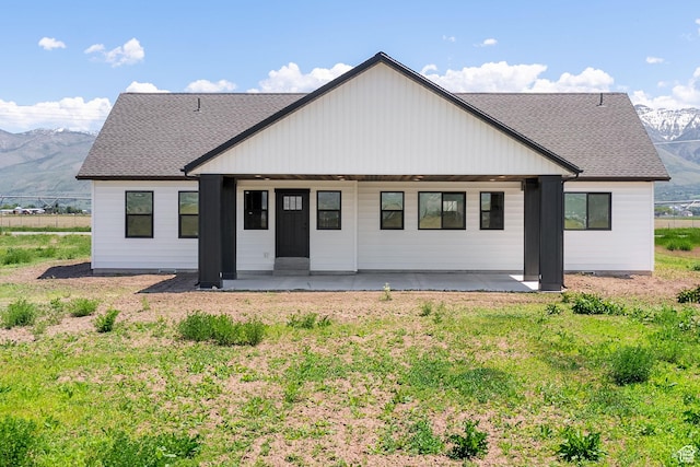 1120 S 800 W, Lewiston, UT 84320 - rear view of house featuring a mountain view, roof with shingles, and a patio area
