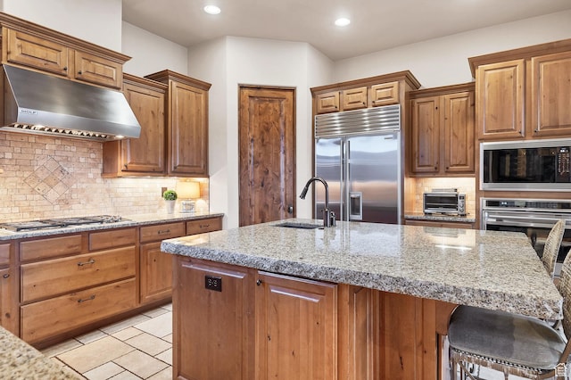 3052 N Snow Canyon Pwky Unit 168, St George, UT 84770 - kitchen featuring built in appliances, under cabinet range hood, a sink, a kitchen bar, and light stone counters