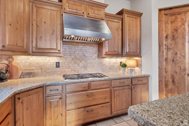 3052 N Snow Canyon Pwky Unit 168, St George, UT 84770 - kitchen featuring under cabinet range hood, stainless steel gas cooktop, decorative backsplash, and light stone counters