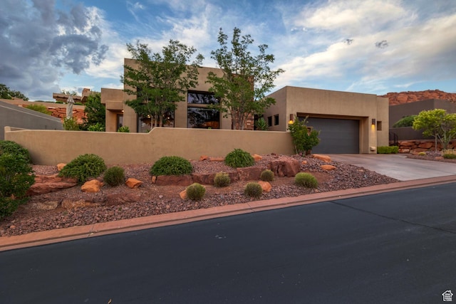 3052 N Snow Canyon Pwky Unit 168, St George, UT 84770 - pueblo revival-style home with a fenced front yard, concrete driveway, stucco siding, and an attached garage