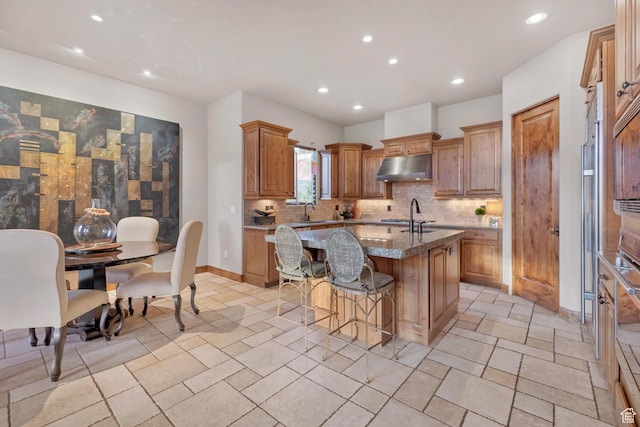 3052 N Snow Canyon Pwky Unit 168, St George, UT 84770 - kitchen with an island with sink, recessed lighting, decorative backsplash, under cabinet range hood, and a sink