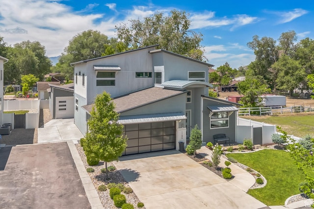 1186 W Marinwood Ave, Murray, UT 84123 - view of front facade featuring driveway, stucco siding, metal roof, a standing seam roof, and an attached garage
