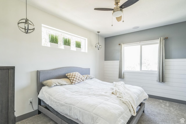 1186 W Marinwood Ave, Murray, UT 84123 - bedroom featuring carpet floors, ceiling fan, wooden walls, and a wainscoted wall